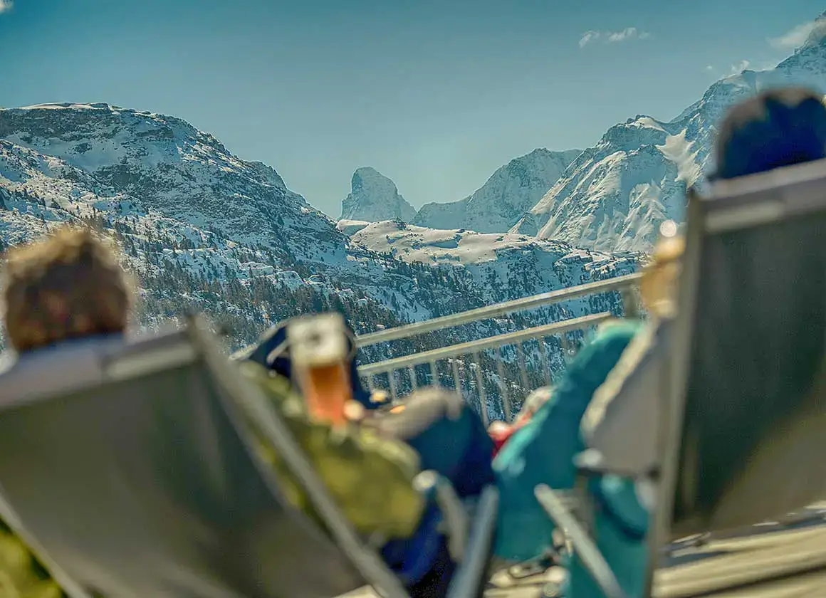 Skifahrer bei der Pause auf der Sonnenterrasse auf der Hannigalp mit Blick auf das Matterhorn